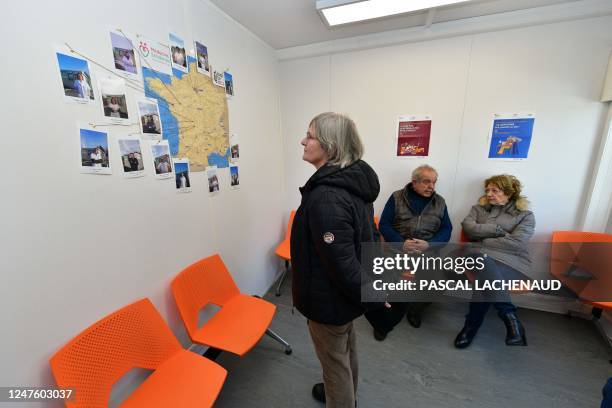 Patient looks at a map of France detailing the origins of their itinerant medical practitionners in the waiting room of the communal medical center...