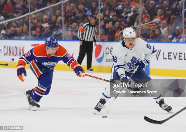 William Nylander of the Toronto Maple Leafs controls the puck against Zach Hyman of the Edmonton Oilers in the first period at Rogers Place on March...