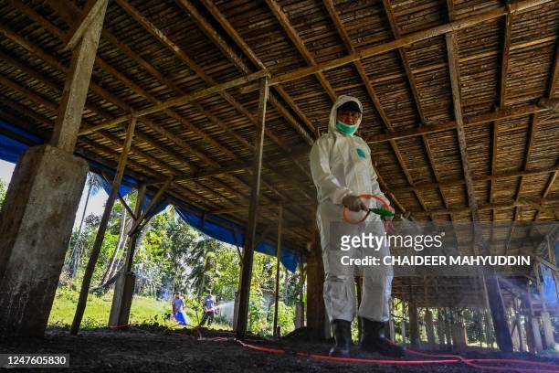 Government worker disinfects a poultry farm against the spread of bird flu in Darul Imarah in Indonesia's Aceh province on March 2, 2023.