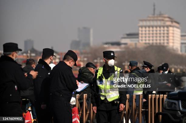 Policemen guard the vicinity at Tiananmen Square ahead of the 14th Committee of the Chinese People's Political Consultative Conference in Beijing on...