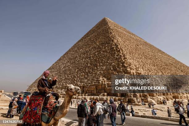 Tourists visit the Great Pyramid of Khufu at the Giza Pyramids necropolis on the southwestern outskirts of Cairo, on March 2, 2023. - A hidden...