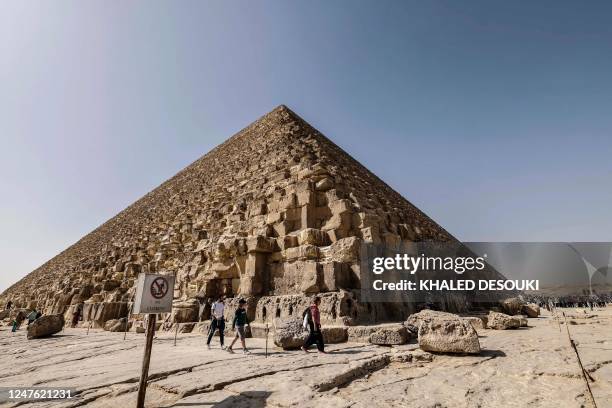 Tourists visit the Great Pyramid of Khufu at the Giza Pyramids necropolis on the southwestern outskirts of Cairo, on March 2, 2023. - A hidden...