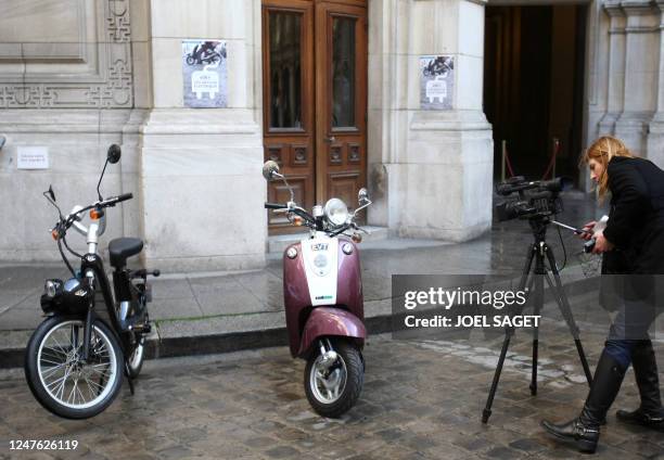 Une photographe photographie des cyclomoteurs électriques présentés le 09 mars 2009 à la mairie de Paris. La municipalité s'engage à verser une aide...