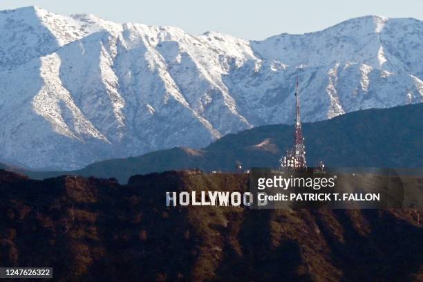 Snow capped mountains stand on the skyline behind a view of the Hollywood sign following heavy rain from winter storms, as seen from the Kenneth Hahn...