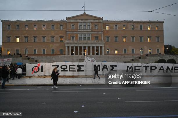 Protesters hold a giant banner translating into "our lives matter" during a demonstration in front of the Greek parliament in Athens, on March 2...