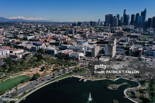 An aerial image shows snow capped mountains on the horizon with the downtown Los Angeles skyline following heavy rain from winter storms as seen...