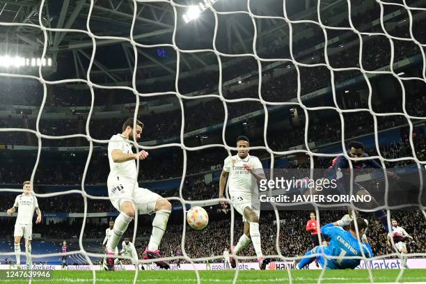 Real Madrid's Brazilian defender Eder Militao scores an own goal next to Barcelona's Ivorian midfielder Franck Kessie during the Copa del Rey semi...