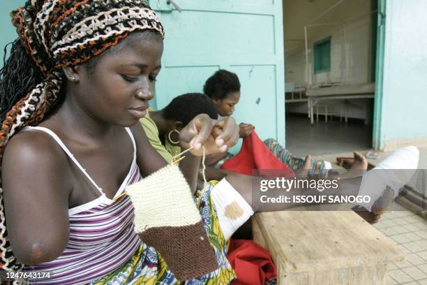 Patients infected with leprosy of the Bruli ulcer, a skin disease closely related to leprosy, knit in front of their hospital room 24 January 2005 at...