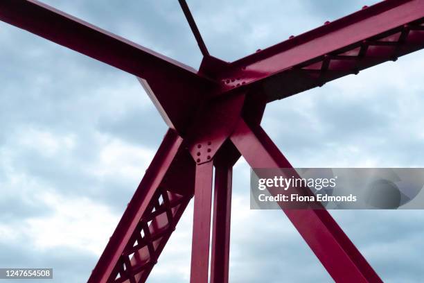 low angle view of intersecting iron beams - building low angle stockfoto's en -beelden