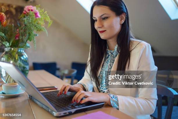 young business woman using laptop at a cafe - aleksandra cvetkovic stock pictures, royalty-free photos & images