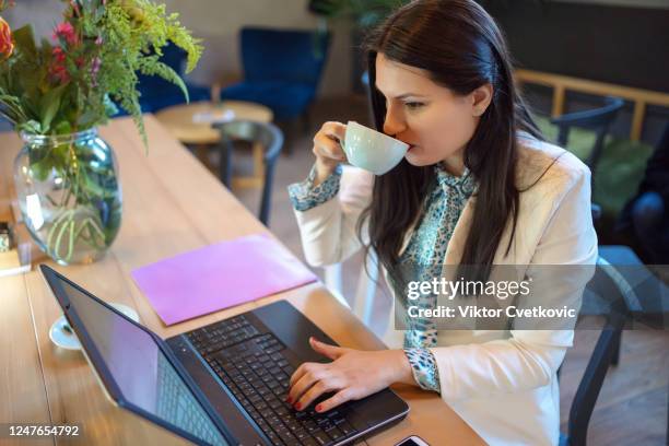 young business woman using laptop at a cafe - aleksandra cvetkovic stock pictures, royalty-free photos & images