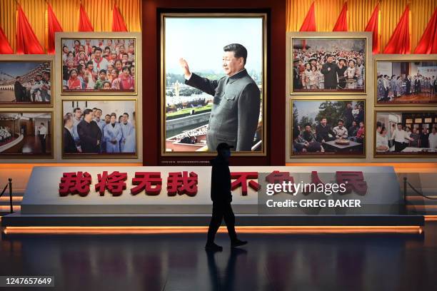 Man walks past a photo of Chinese President Xi Jinping at the Museum of the Communist Party of China in Beijing on March 3 ahead of the opening of...