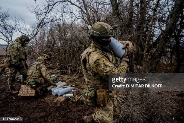 Ukrainian serviceman carries a 152 mm shell to fire a Msta-B howitzer towards Russian positions, near the frontline town of Bakhmut on March 2 amid...