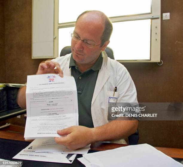 Philippe Renaux chirurgien libéral à Abbeville montre, le 24 août 2004 dans son bureau de la clinique Sainte-Isabelle à Abbeville, son billet d'avion...