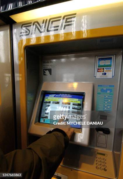 Un voyageur utilise une billetterie automatique le 09 février 2005 à la gare SNCF de Caen. La direction de la SNCF a annoncé avoir présenté, la...