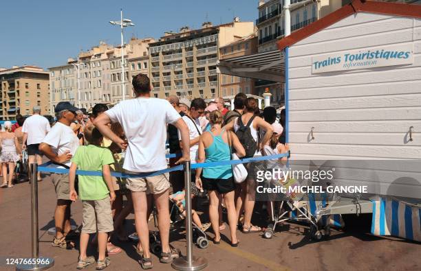Des touristes patientent le 31 juillet 2008 sur le Vieux port de Marseille à la billeterie du petit train touristique afin de visiter la cité...