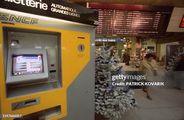 Une personne passe près d'un distributeur de billets de train, le 16 décembre 1999 en gare Montparnasse à Paris, à deux semaines de l'an 2000. La...