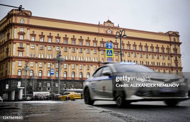 Police car goes past the headquarters of the Federal Security Service , the successor agency to the KGB, and Lubyanka Square in front of it in...