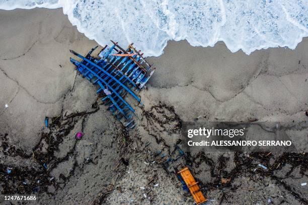 An aerial photograph taken on February 28, 2023 shows pieces of wood washed up on the beach, two days after a boat of migrants sank off Italy's...