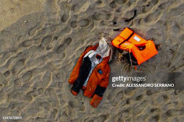 An aerial photograph taken on February 28, 2023 shows a jacket and a life jacket washed up on the beach, two days after a boat of migrants sank off...