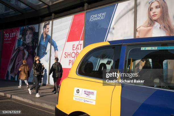 Passers-by and a new retail space opportunity hoarding in the City of London, the capital's financial district, on 2nd March 2023, in London, England.