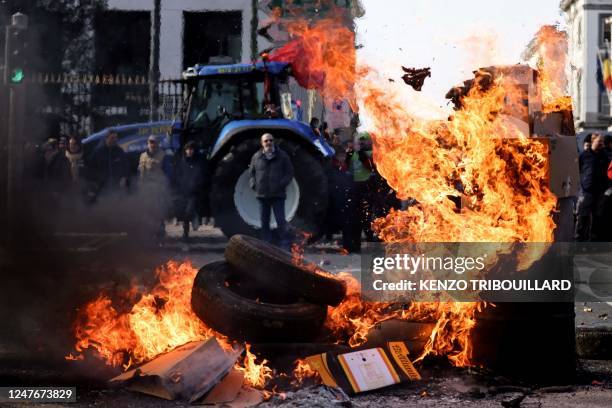 Protesters stand near burning tyres during a demonstration called by Flemish farmers to protest against new proposed rules to reduce nitrogen...