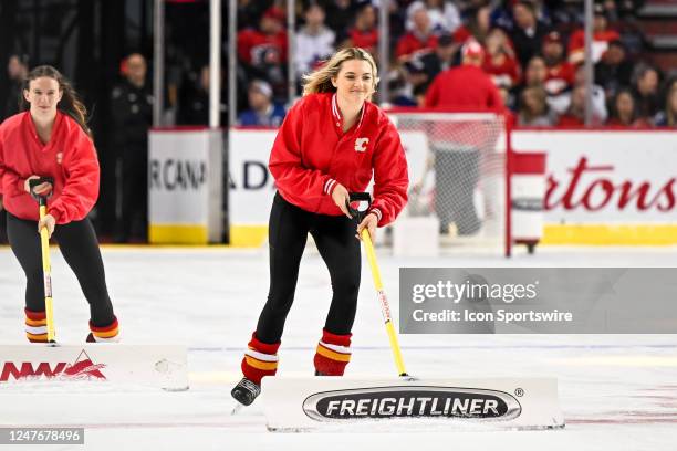 Calgary Flames ice girls clean the ice during the second period of an NHL game between the Calgary Flames and the Toronto Maple Leafs on March 2 at...