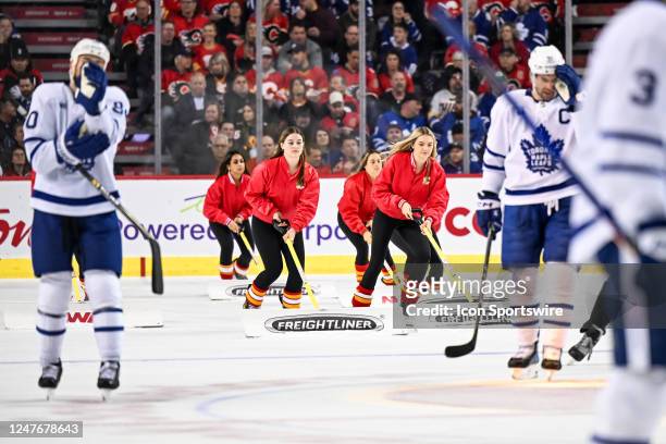 Calgary Flames ice girls clean the ice during the third period of an NHL game between the Calgary Flames and the Toronto Maple Leafs on March 2 at...