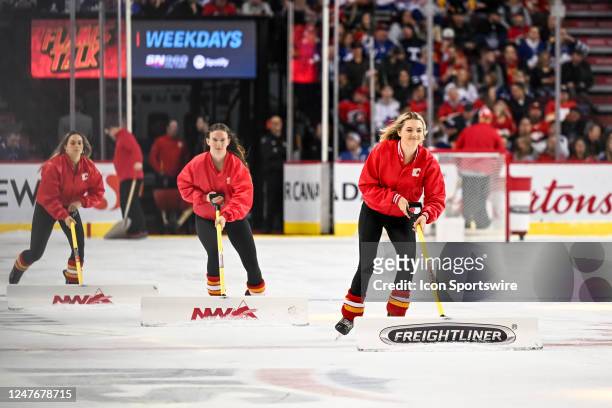 Calgary Flames ice girls clean the ice during the second period of an NHL game between the Calgary Flames and the Toronto Maple Leafs on March 2 at...