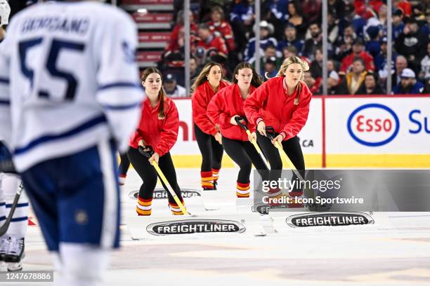 Calgary Flames ice girls clean the ice during the third period of an NHL game between the Calgary Flames and the Toronto Maple Leafs on March 2 at...