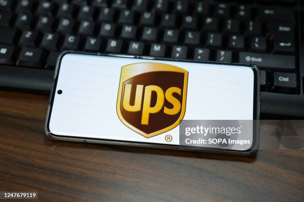 In this photo illustration, a United Parcel Service logo is displayed on the screen of a smartphone.