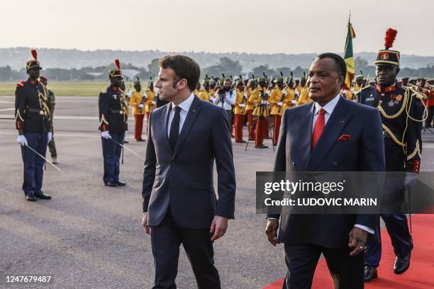 French President Emmanuel Macron and Congolese President Denis Sassou-Nguesso review a guard of honour upon Macron's arrival at the airport in...