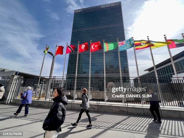 People walk past United Nations headquarters in New York on March 3, 2023. - UN countries were trying to overcome their differences on March 3 to...