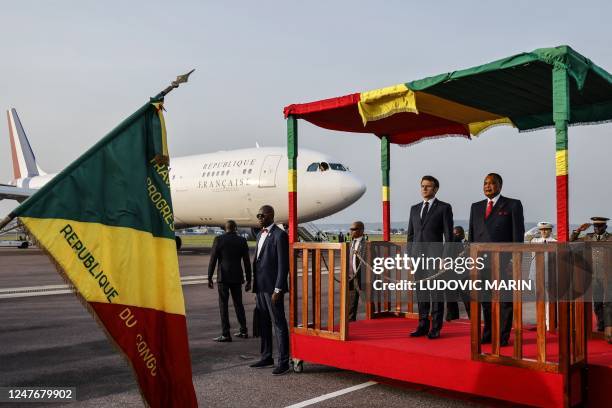 French President Emmanuel Macron and Congolese President Denis Sassou-Nguesso attend a welcoming ceremony upon Macron's arrival at the airport in...