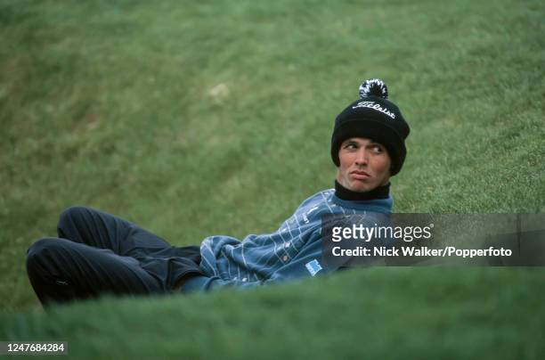 Andrew Coltart of Scotland shelters from the cold wind during the third round of the Benson & Hedges International Open at The Oxfordshire Golf Club...