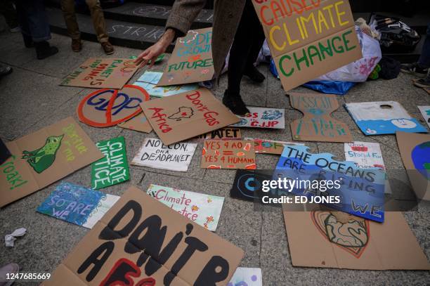 An activist picks up a placard at climate group Fridays for Future's march during a Global Climate Strike in New York on March 3, 2023.