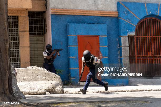Haitian National Police move into position as they attempt to repel gangs in a neighborhood near the Presidential Palace in the center of...