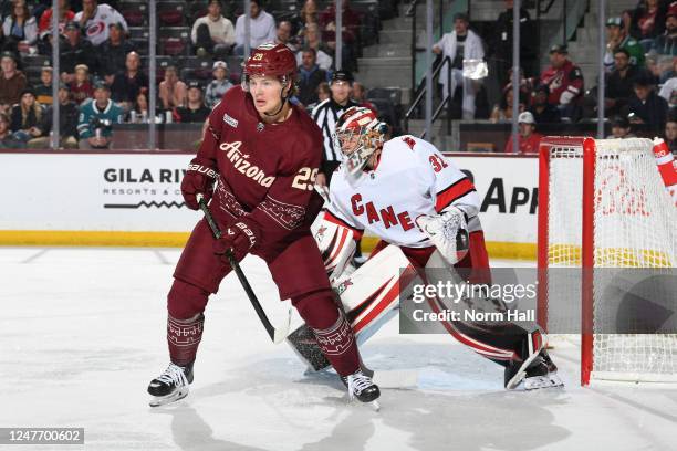 Barrett Hayton of the Arizona Coyotes screens Antti Raanta of the Carolina Hurricanes during the first period at Mullett Arena on March 03, 2023 in...