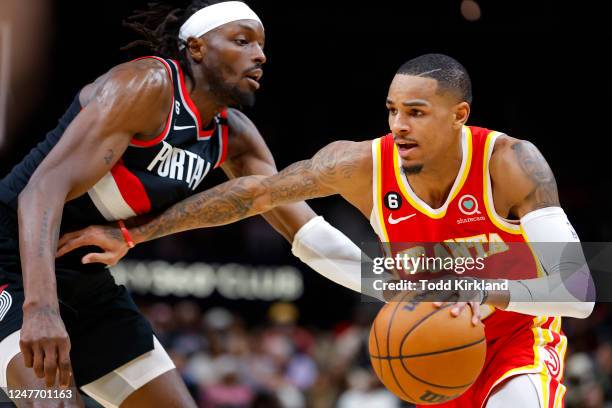 Dejounte Murray of the Atlanta Hawks is defended by Jerami Grant of the Portland Trail Blazers during the second half at State Farm Arena on March 3,...