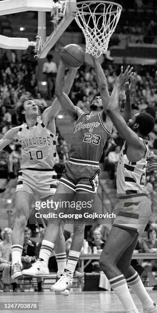 Forward Rowland Garrett of the Chicago Bulls rebounds against guard Dick Snyder and center Jim Chones of the Cleveland Cavaliers during a National...