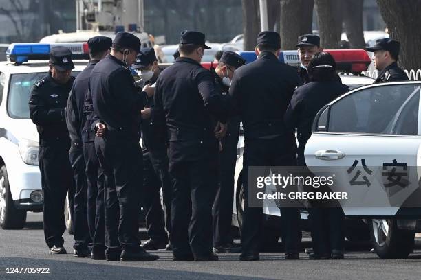 Police officers stand on a road south of the Great Hall of the People ahead of the opening session of the Chinese People's Political Consultative...