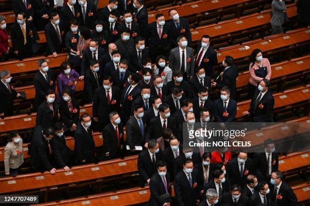 Delegates leave after the opening ceremony of the Chinese People's Political Consultative Conference at the Great Hall of the People in Beijing on...