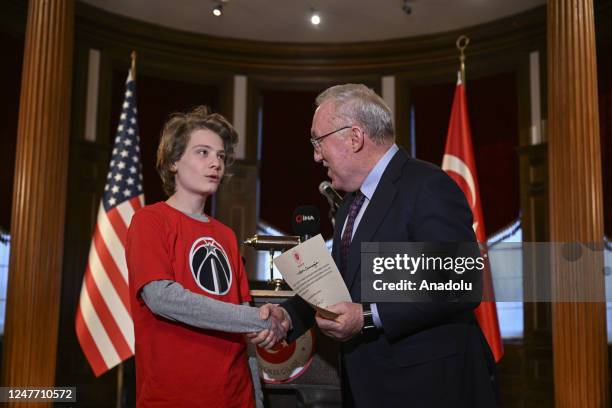 Turkiyeâs Ambassador to Washington, Hasan Murat Mercan presents a certificate of appreciation to a volunteer who participated in the aid campaign...