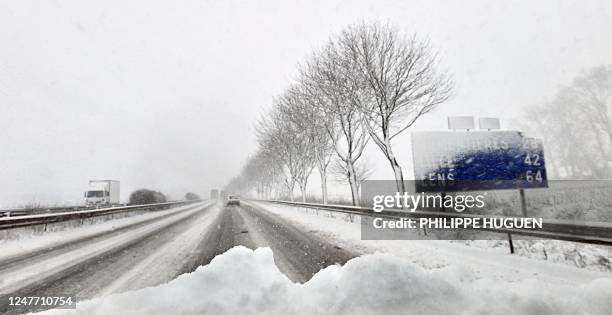 Motorists are pictured on the snow-covered highway A25, near Steenvoorde, northern France, on February 10 as a result of heavy snow falls. AFP PHOTO...