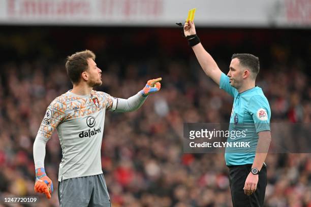 Bournemouth's Brazilian goalkeeper Neto argues as he receives a yellow card during the English Premier League football match between Arsenal and...
