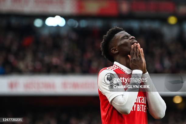 Arsenal's English midfielder Bukayo Saka reacts after missing to score during the English Premier League football match between Arsenal and...