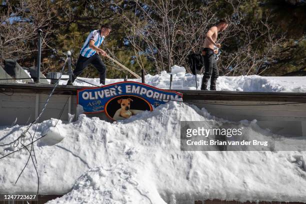 Men shovel snow off the roof of a Big Bear Village gift shop digs out following successive storms which blanketed San Bernardino Mountain communities...