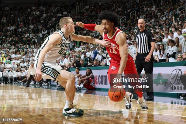 Justice Sueing of the Ohio State Buckeyes drives baseline against Joey Hauser of the Michigan State Spartans during the second half at Breslin Center...