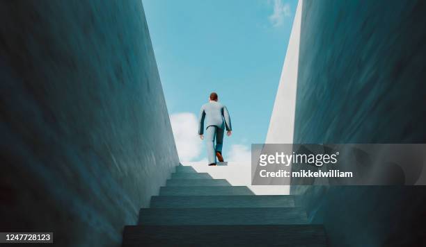 man walks the ladder of success and reaches the top - staircase stock pictures, royalty-free photos & images