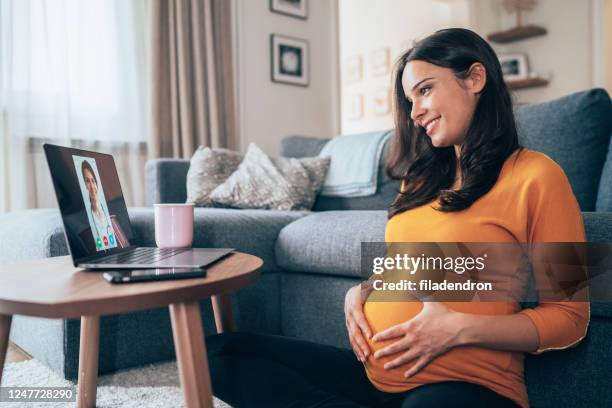 pregnant woman having video call with doctor - pregnant woman stock pictures, royalty-free photos & images